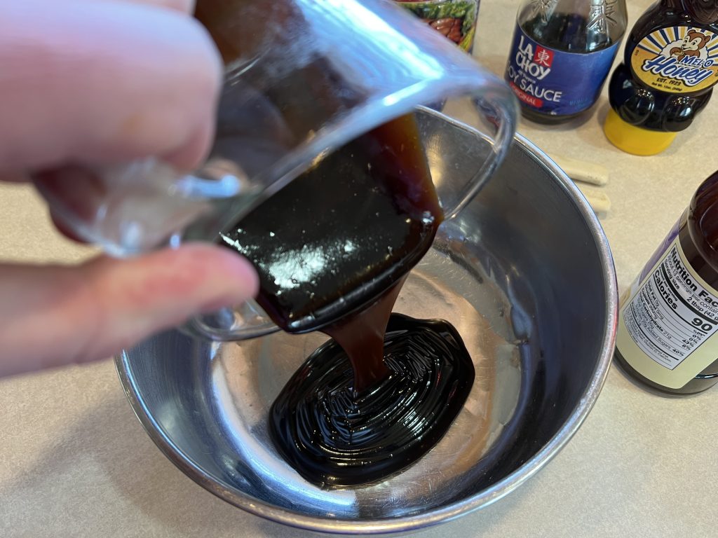 Pouring hoisin sauce into large bowl