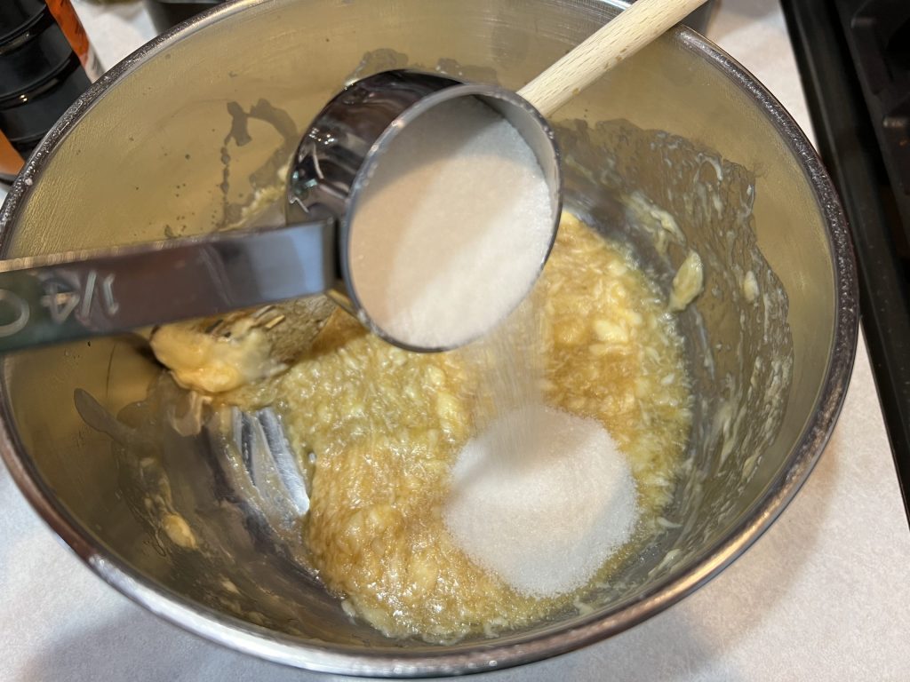 Dumping sugar into bowl of mixture