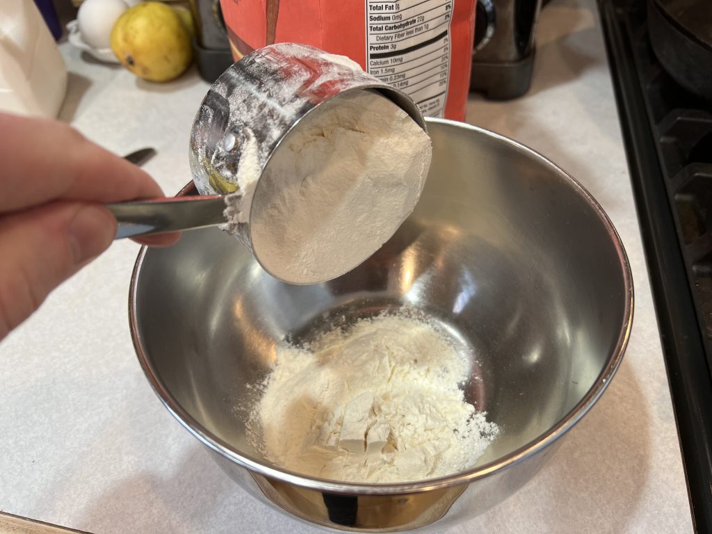 pouring flour into mixing bowl
