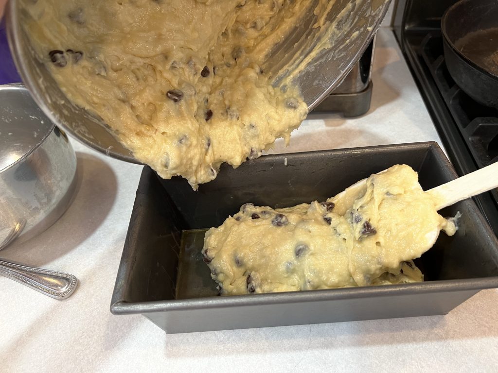 pouring banana bread batter into loaf pan