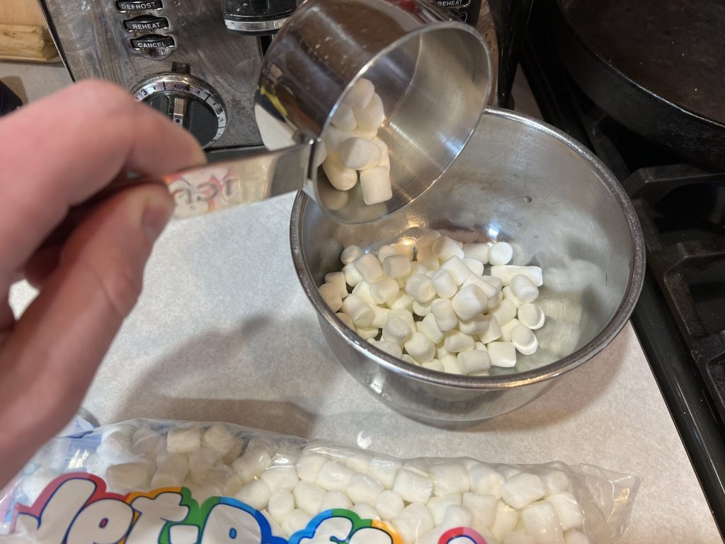 measuring out mini marshmallows for Rice Krispie Treat recipe