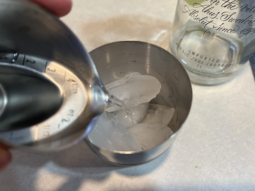 pouring vodka into a shaker