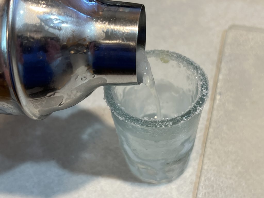 pouring lemon drop shot into glass