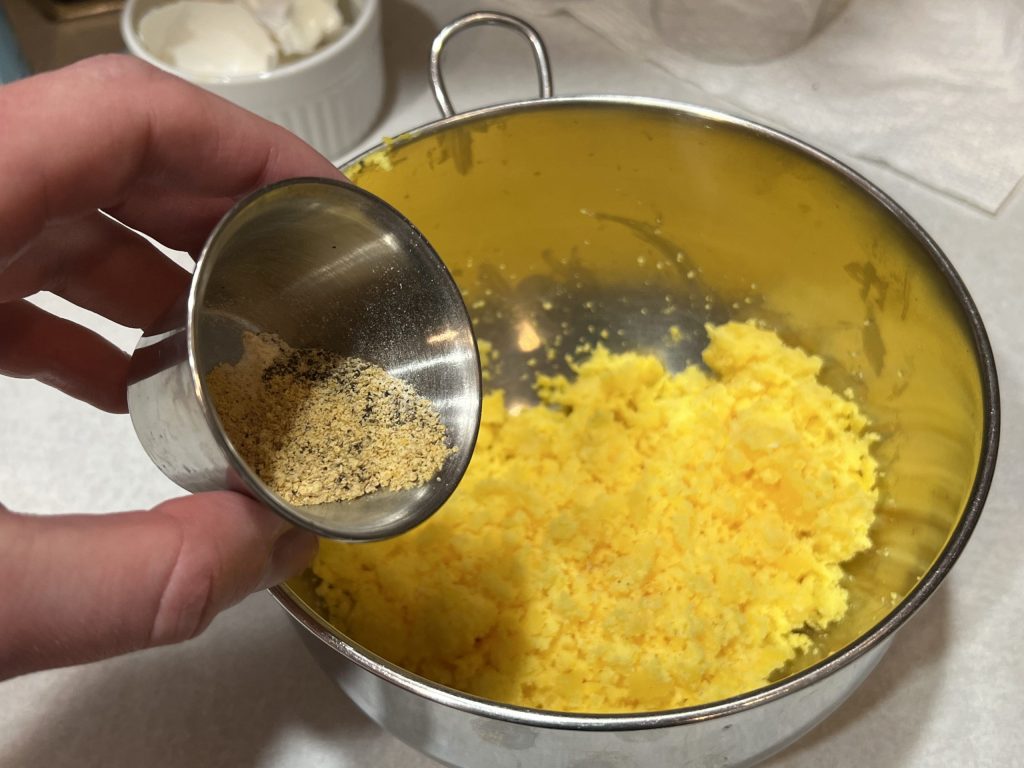 dumping seasoning into egg yolks