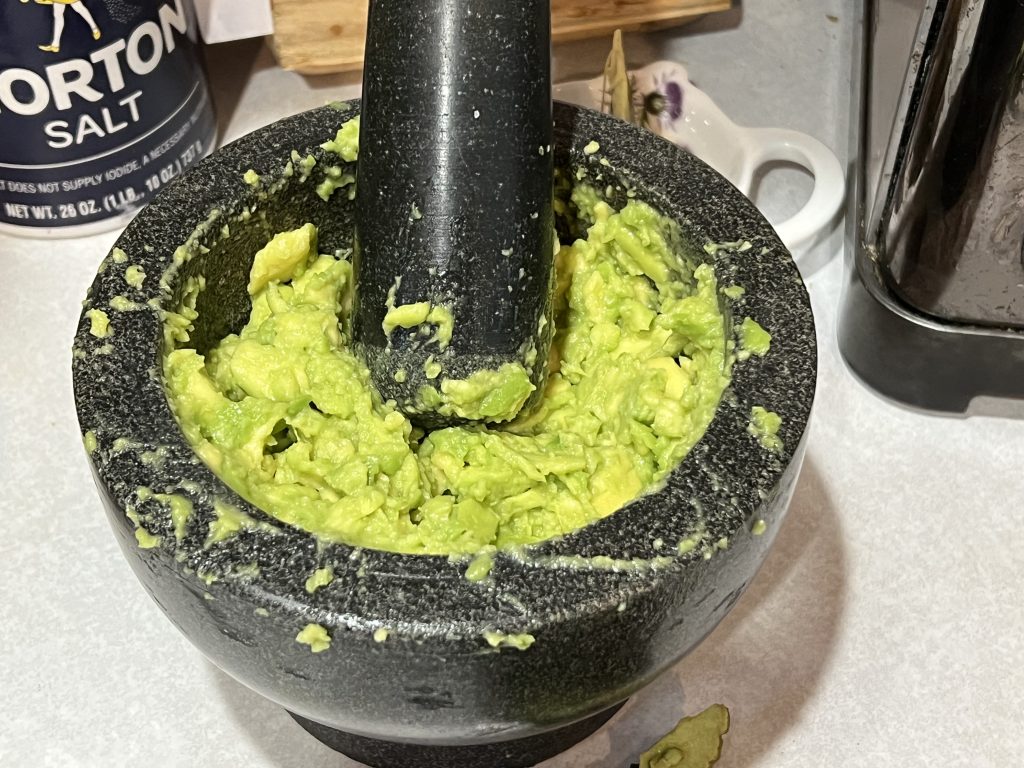 mortar and pestle smashing avocado