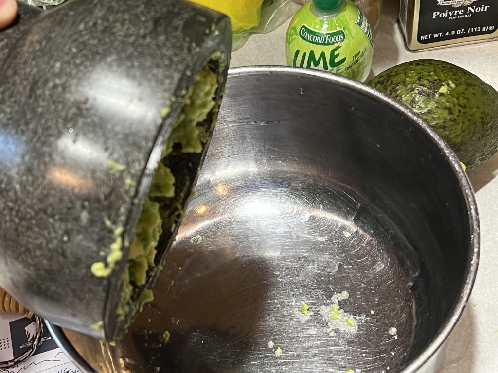 dumping guacamole into large bowl for a guacamole recipe