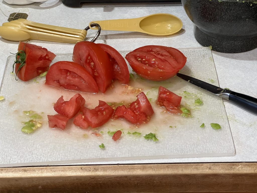 chopping up tomatoes for guacamole recipe