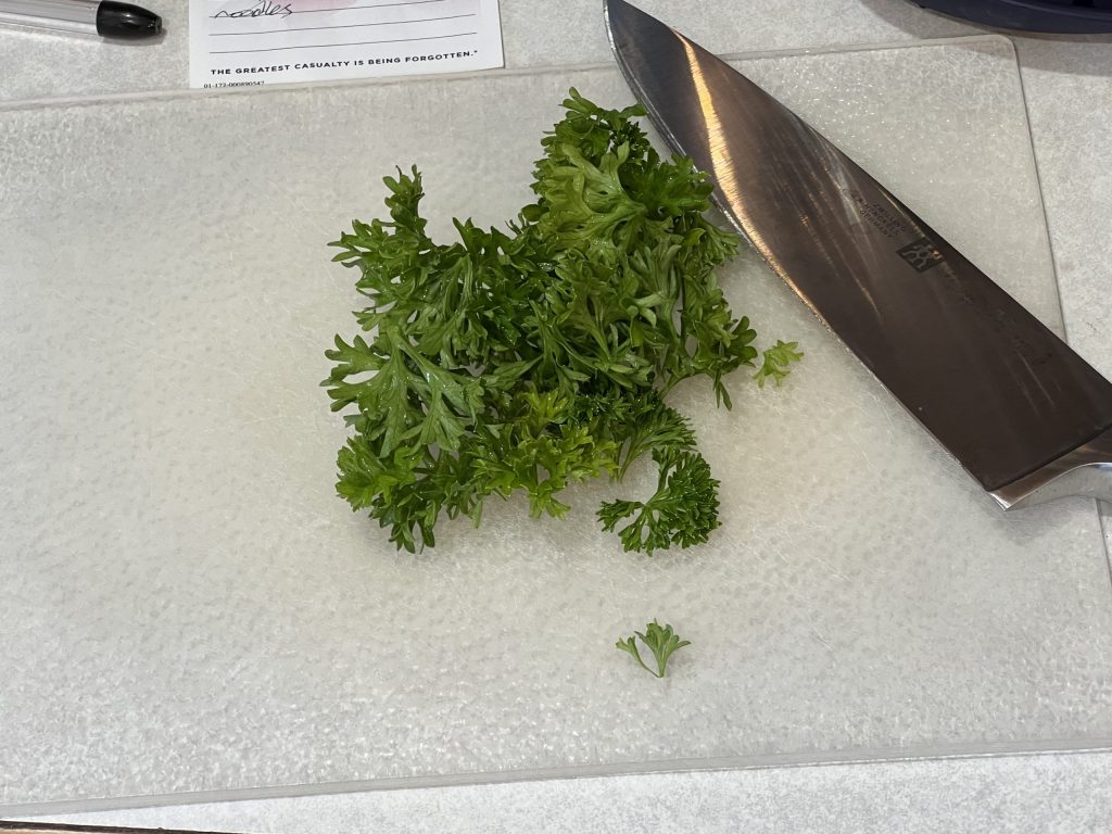 chopping up parsley for cavatappi pasta recipe