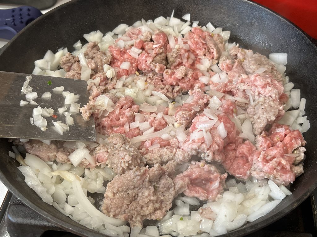 cooking meat and onions for cavatappi pasta recipe