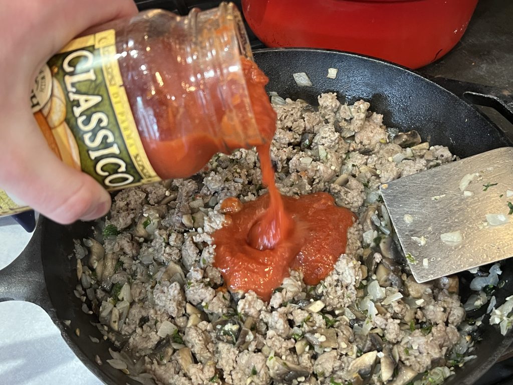 sauce in skillet with meat and other ingredients for pasta recipe