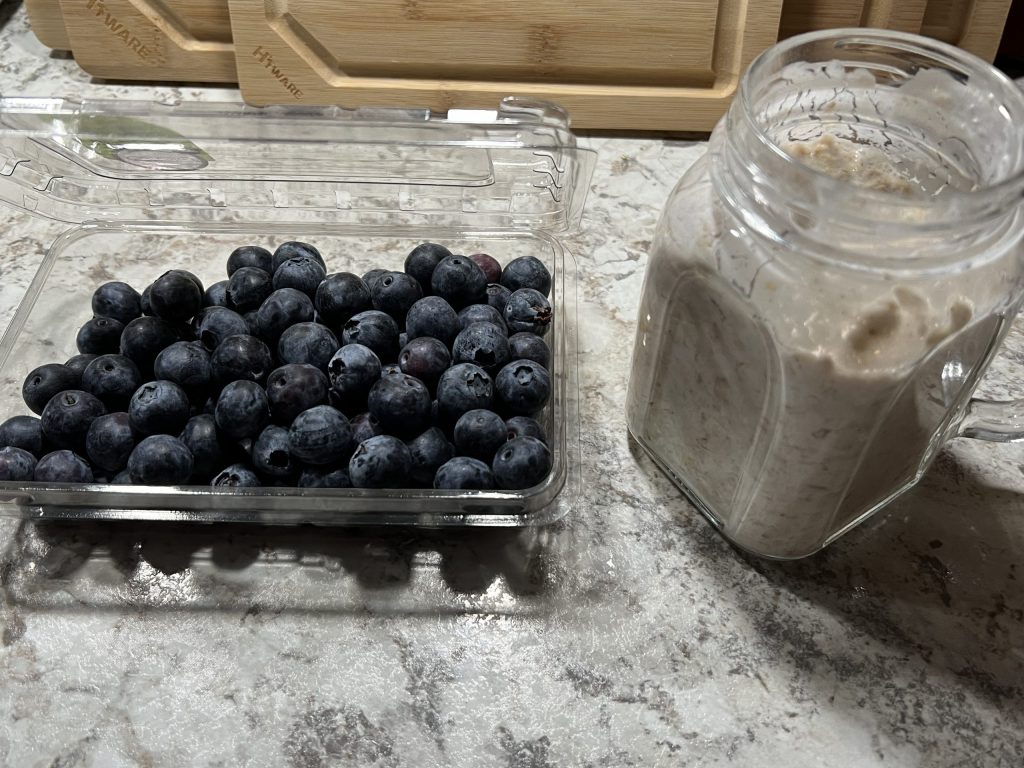 blueberries and a mason jar with overnight oats in it.