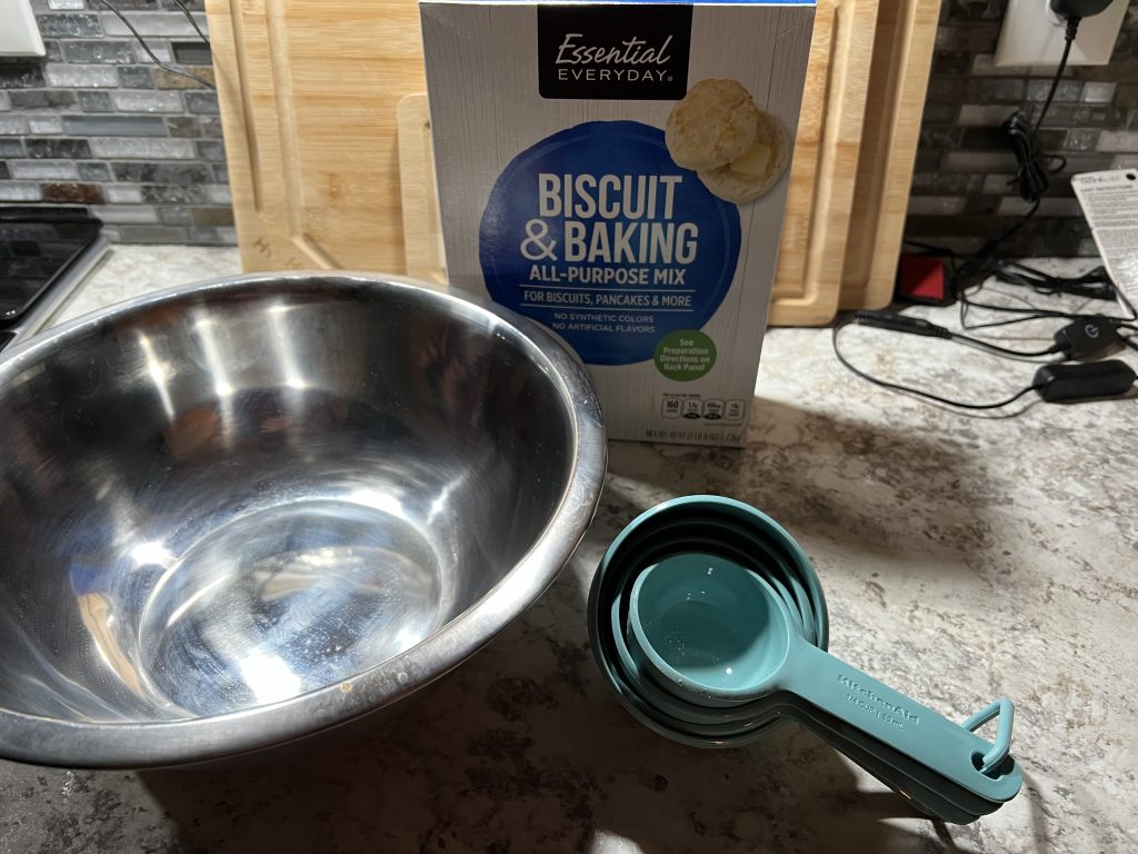 measuring cups, mixing bowl, and biscuit and baking mix.
