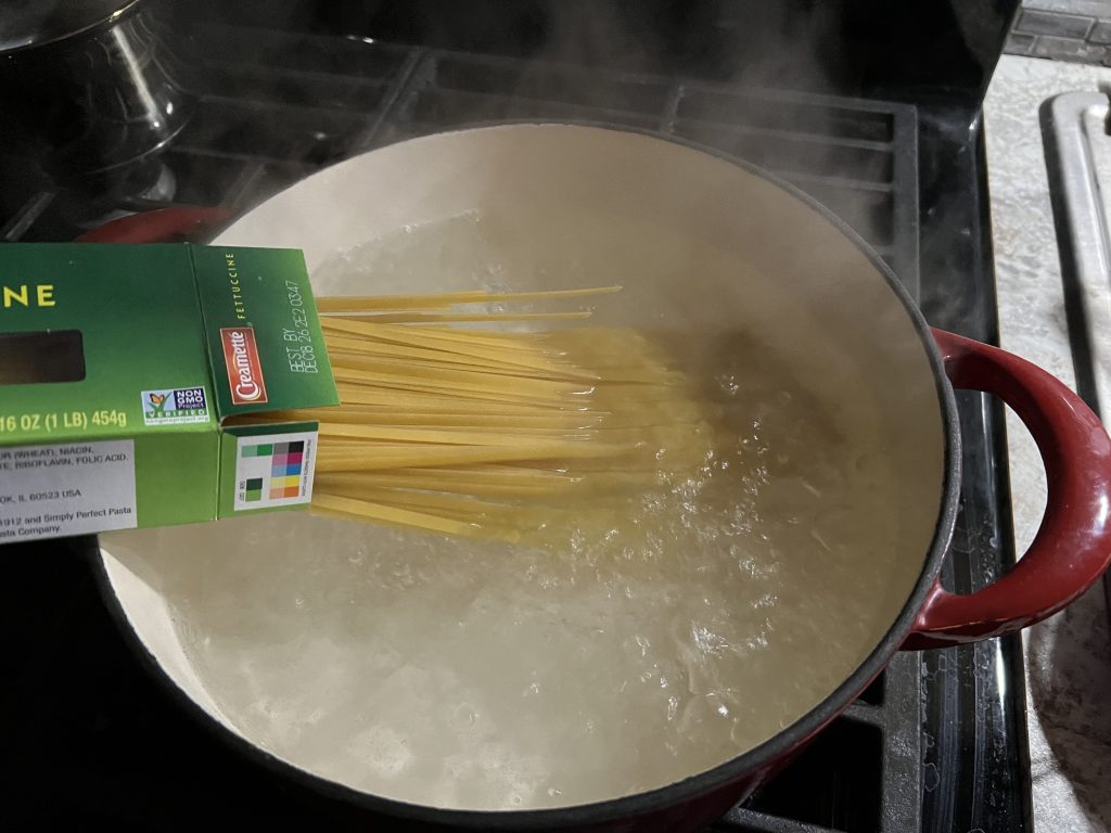 putting raw pasta in boiling water