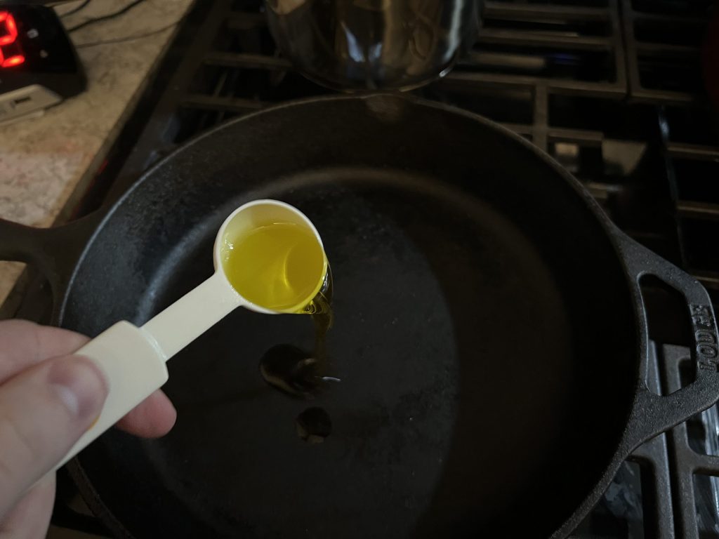 putting olive oil in skillet for chicken alfredo recipe