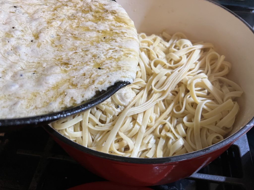 pouring sauce into noodles